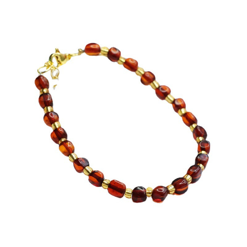 Bracelet en perles d'ambre naturel et perles dorées, modèle Trésor Doré, élégant bijou artisanal sur fond blanc.