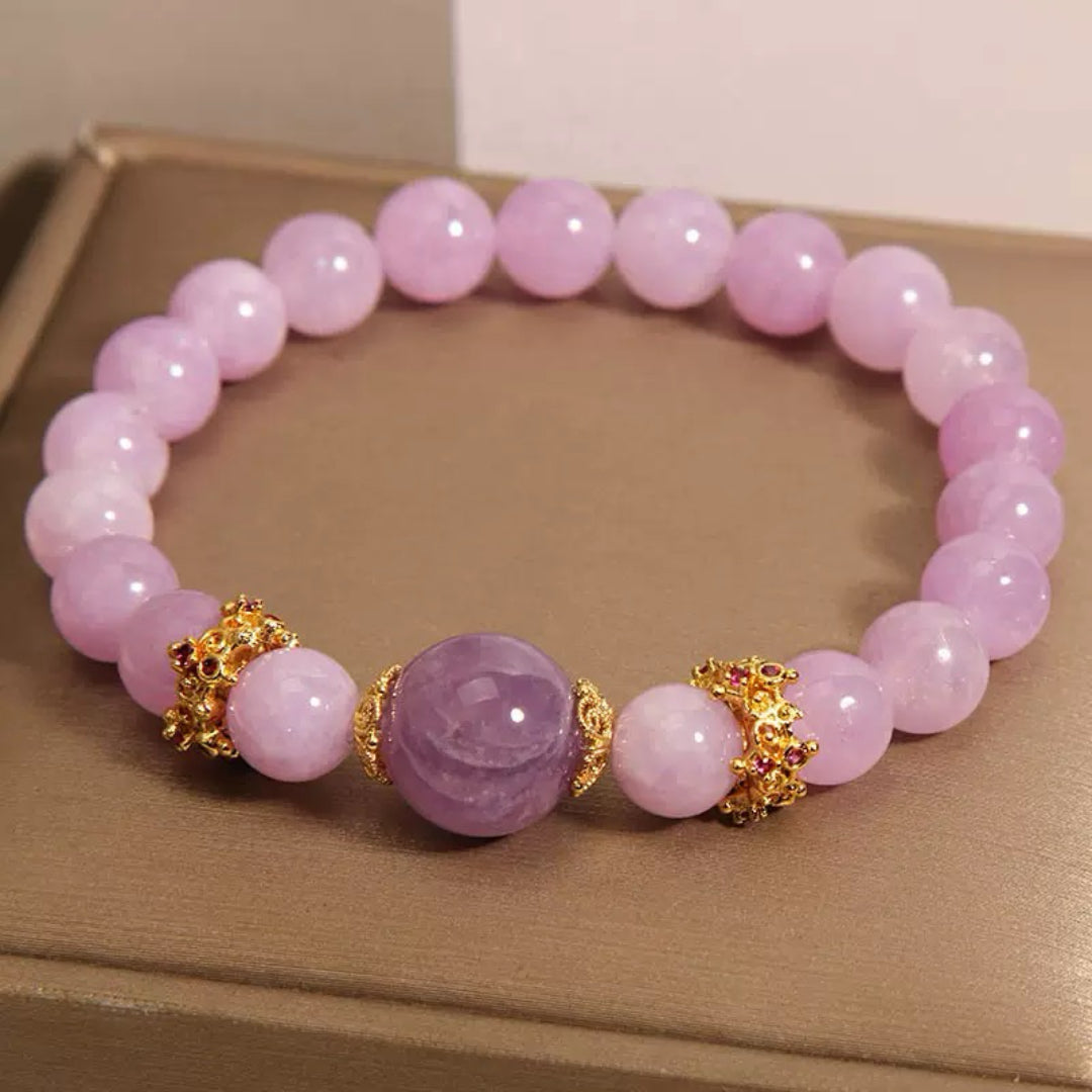 Bracelet en pierres d'améthyste et perles roses pâles, orné de fermoirs dorés et de petites pierres rouges.