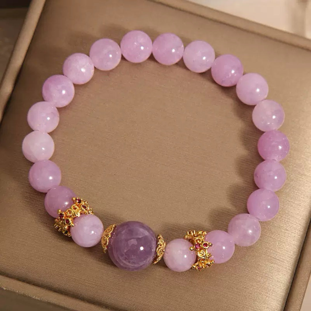 Bracelet en perles d'améthyste lavande avec des détails dorés et des accents de rubis, orné d'une grande pierre centrale d'améthyste.