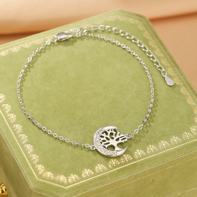 Bracelet Arbre de Vie Lunaire en argent avec un motif d'arbre stylisé intégré dans un croissant de lune orné de petites pierres scintillantes.