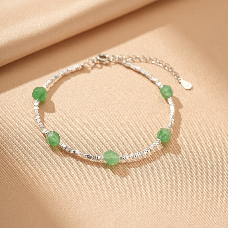 Bracelet en argent avec des perles d'aventurine verte facetées disposées le long d'une chaîne finement texturée.