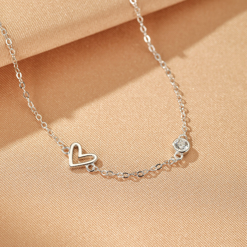 Bracelet Cœur – Éclat du Cœur en argent, orné d'un pendentif cœur ajouré et d'un cristal scintillant.