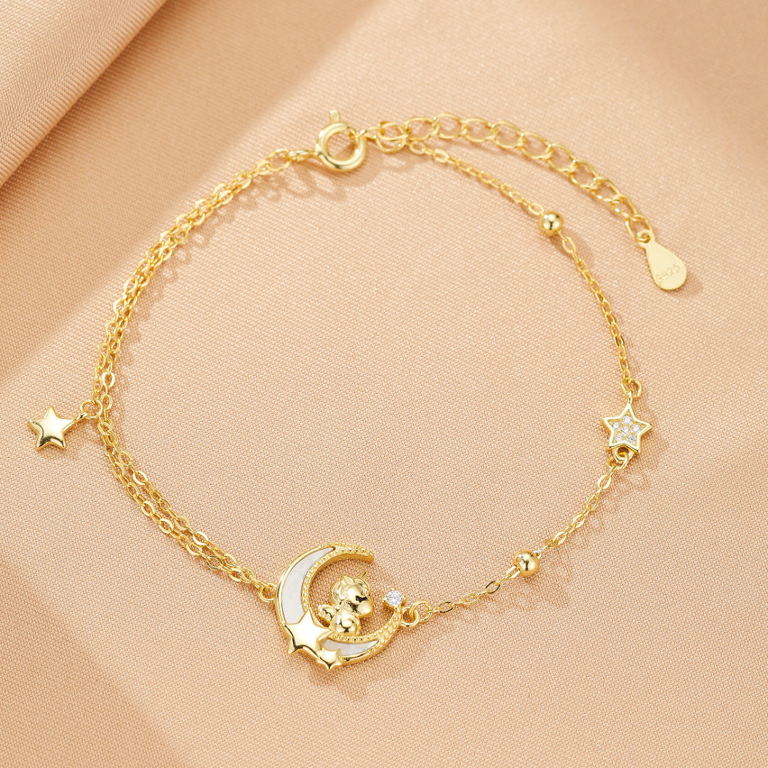 Bracelet Cheval Rêve Étoilé en argent plaqué or, avec pendentif cheval et lune orné de zircons scintillants, porté sur une fine chaîne dorée.