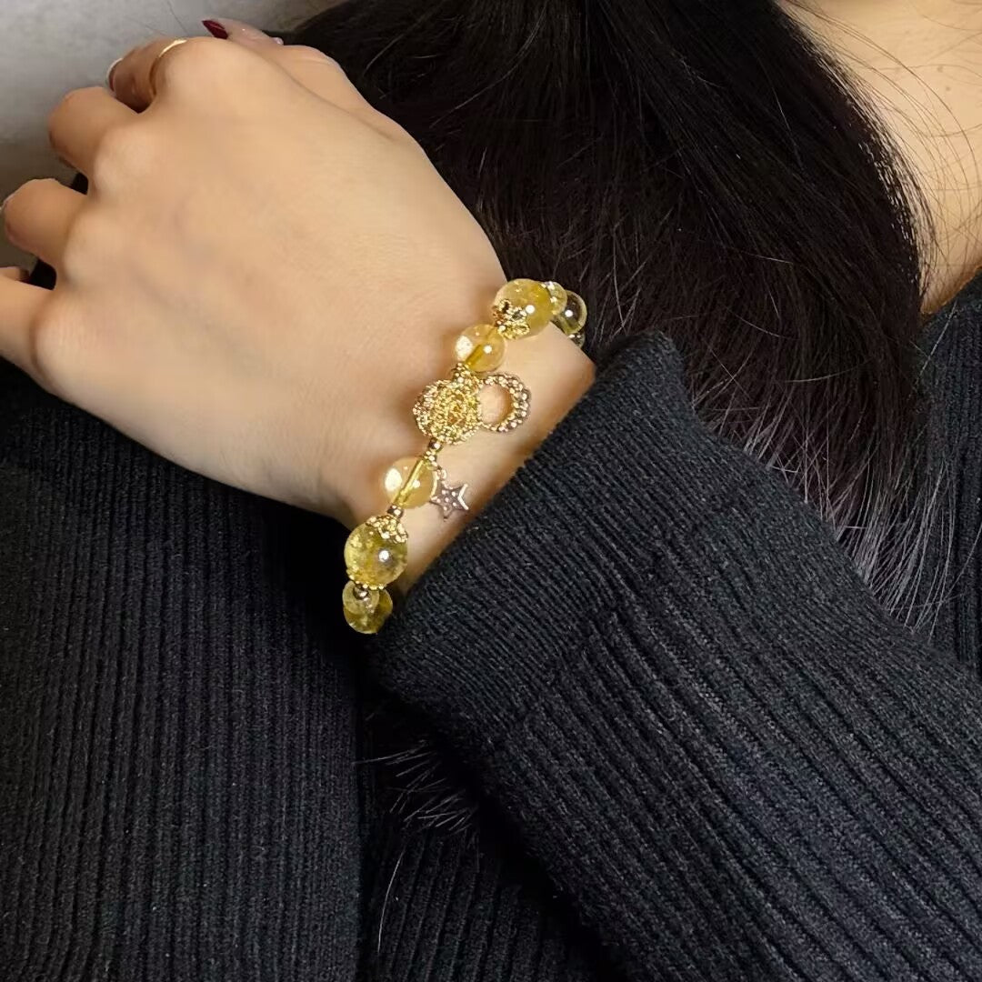 Bracelet Citrine Lune et Étoile, fait main, avec des pierres jaunes naturelles et un fermoir doré en forme de lune et d'étoile, porté au poignet.