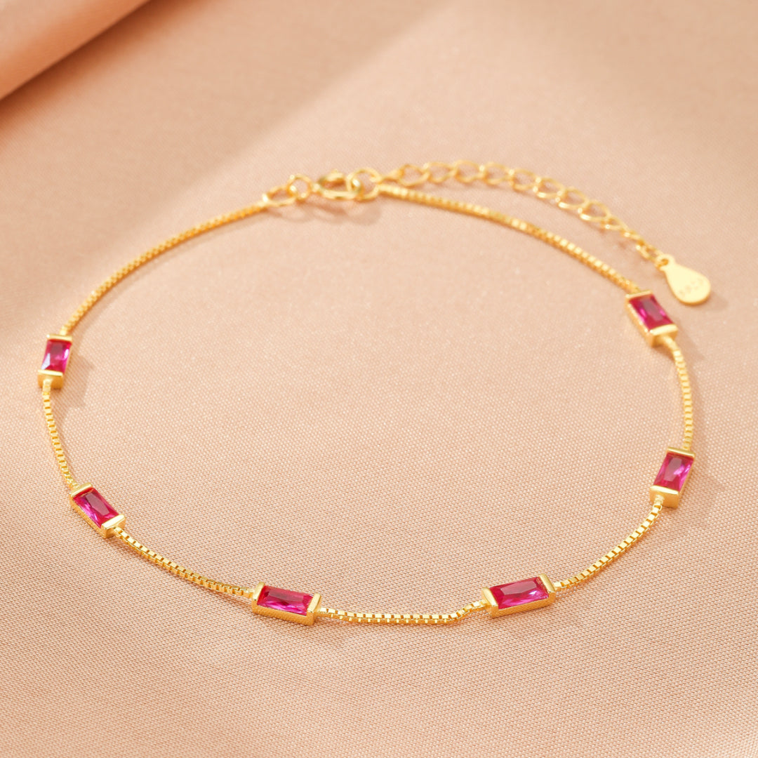 Bracelet fin en argent doré orné de pierres rectangulaires roses, style minimaliste et élégant.