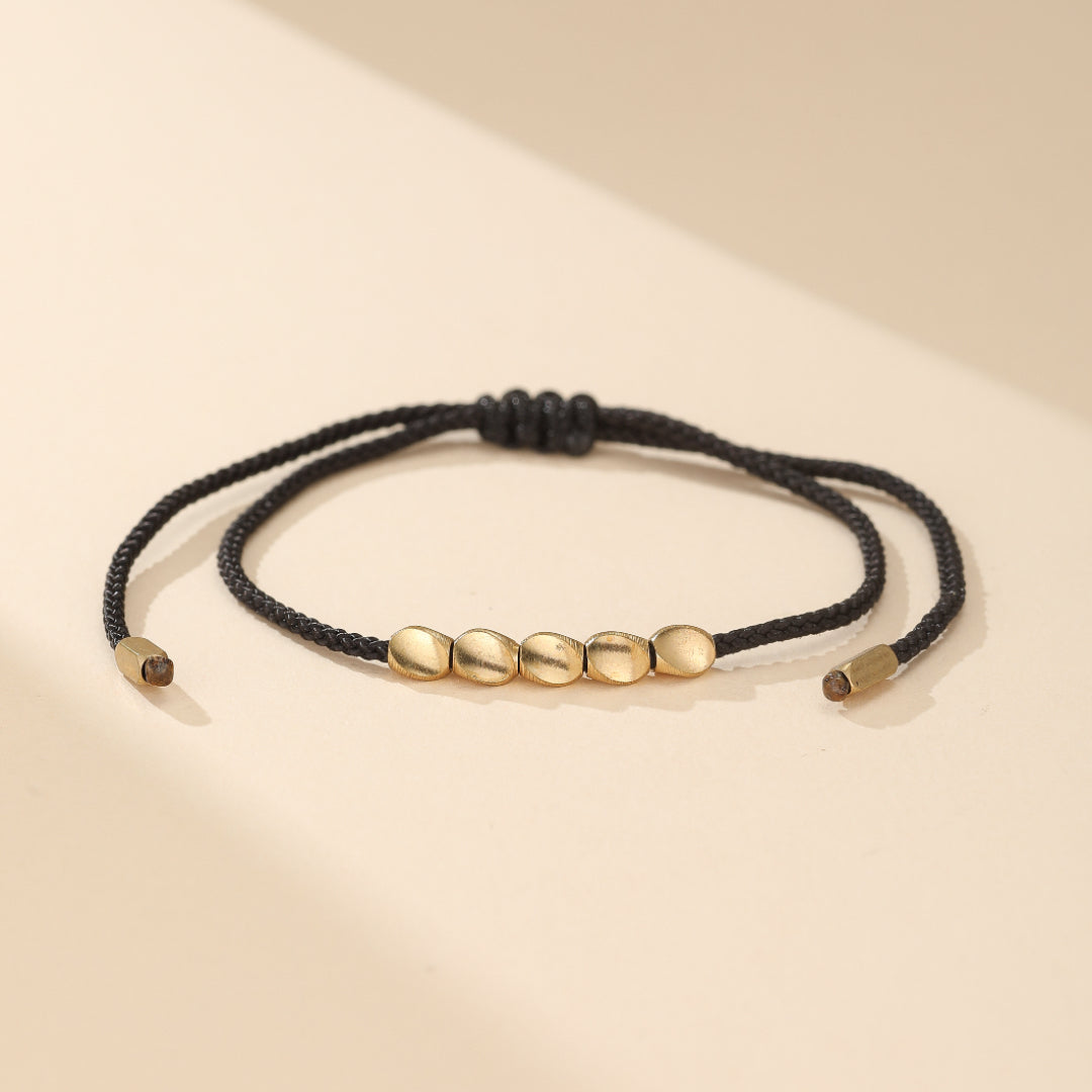 Bracelet d'amitié ou de couple "Flot" en fil rouge du destin, avec son système coulissant et perles en cuivre, un cadeau symbolique pour entretenir un lien invisible puissant et élégant.