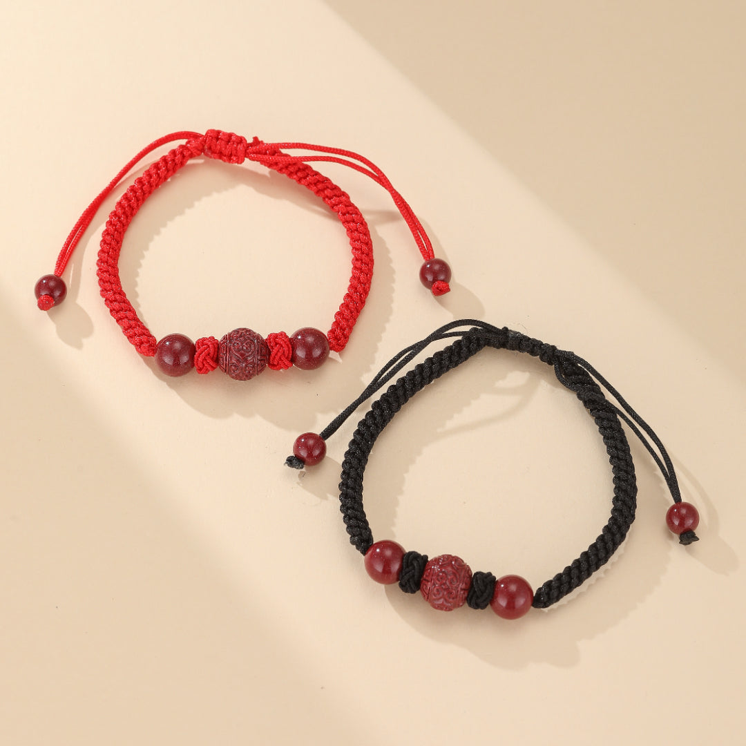 Bracelet couple Amour Zen en fil rouge tissé main avec perles de cinabre sculptées, symbolisant l'union et la sérénité pour partenaires spirituellement connectés.
