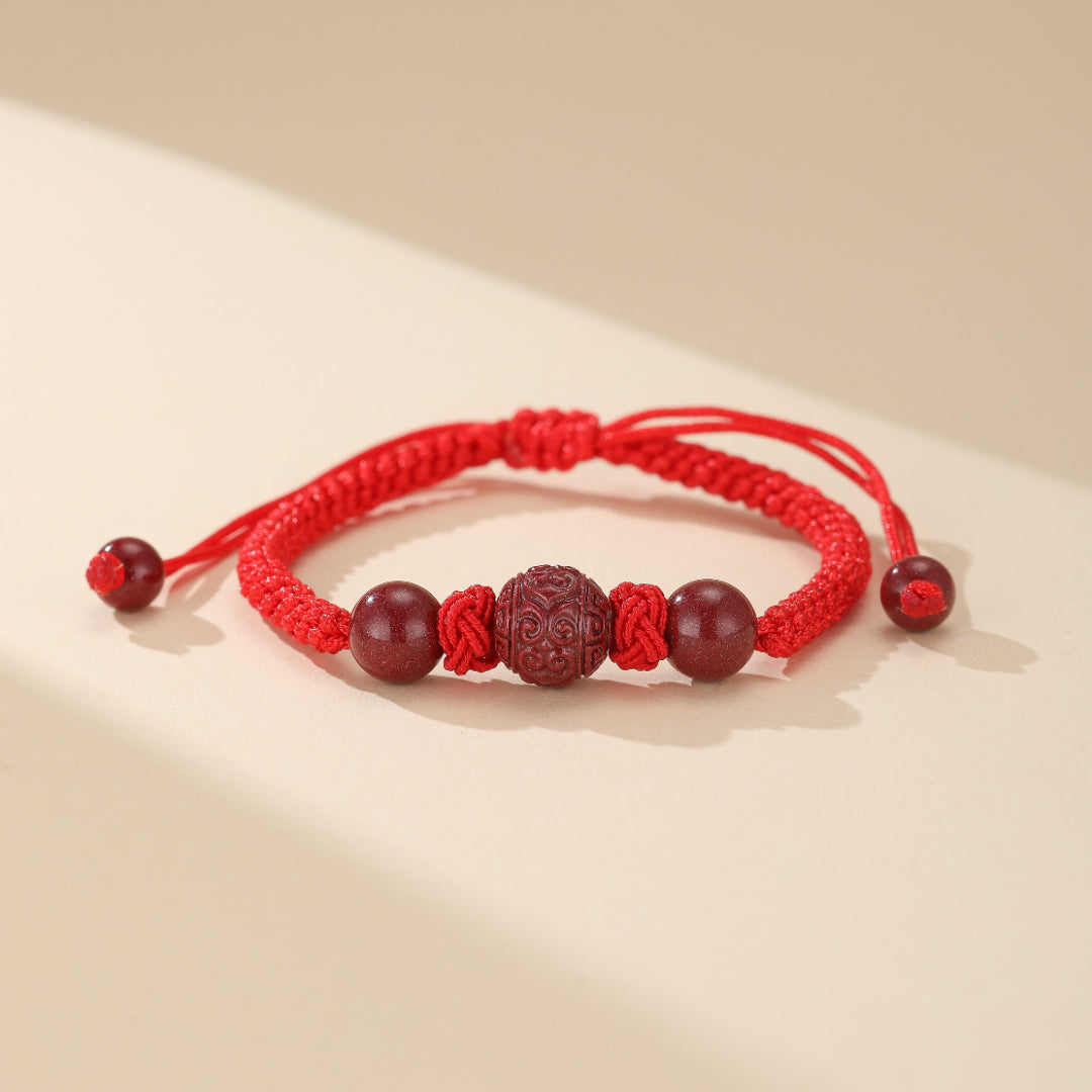 Détail du bracelet Amour Zen: perles de cinabre naturelles et fil rouge tressé, bijou artisanal pour renforcer l'harmonie et offrir protection spirituelle au couple.