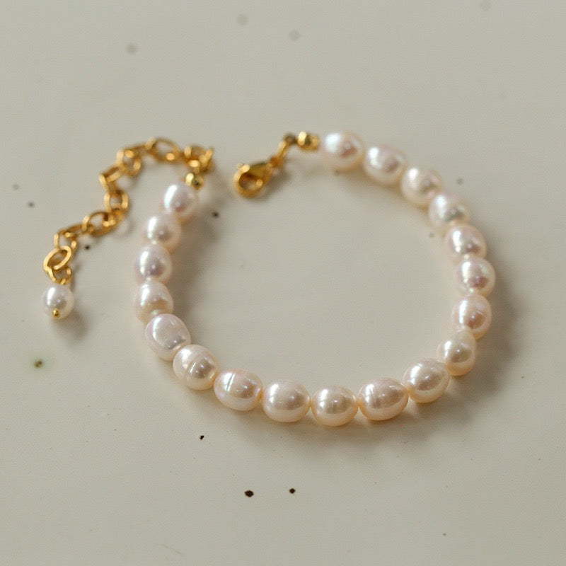 Bracelet de cheville en plaqué or avec des perles baroques blanches et une chaîne ajustable se terminant par une petite perle.
