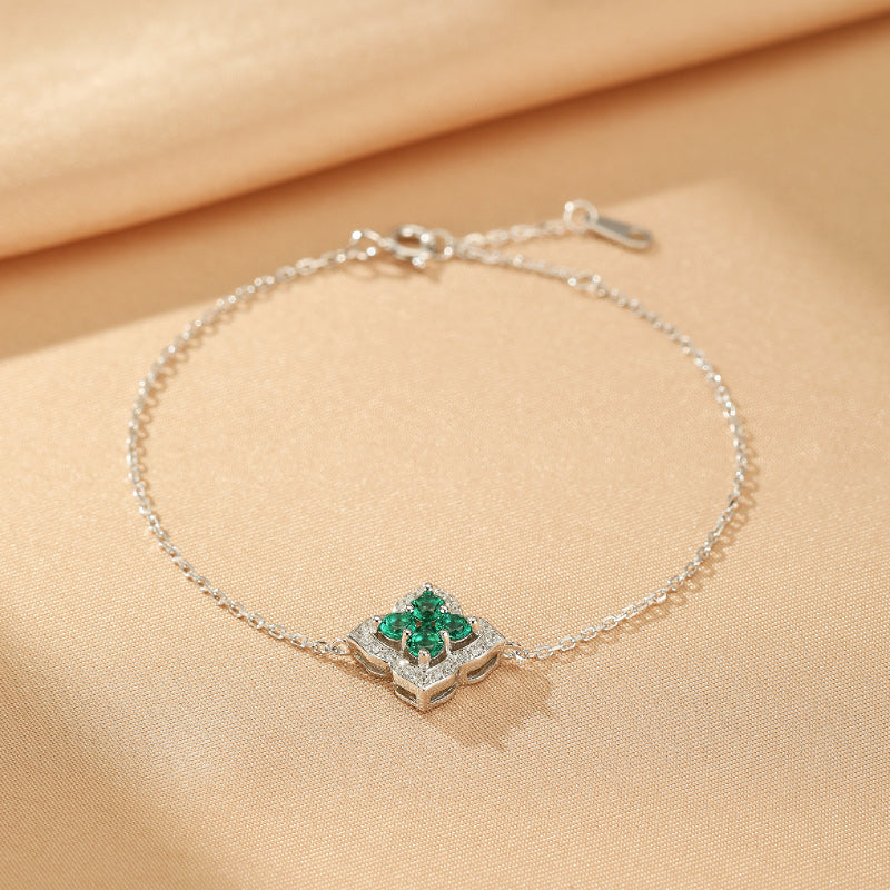 Bracelet en argent 925 orné d'une fleur de chance sertie d'émeraudes et de diamants.