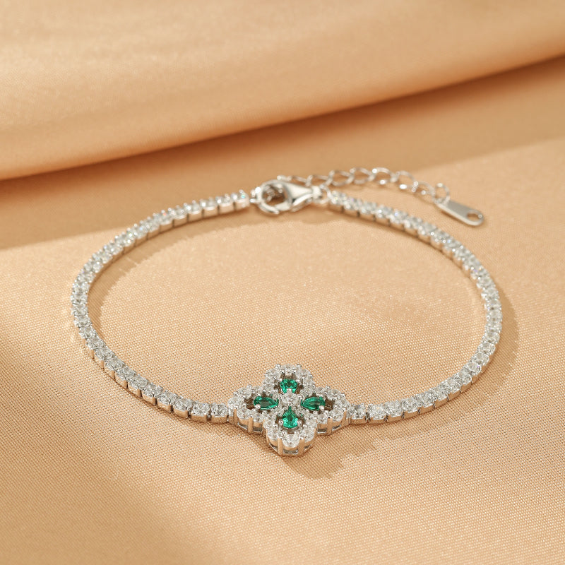 Bracelet tennis en argent 925 orné d'un pendentif trèfle à quatre feuilles serti de pierres d'émeraude et de cristaux blancs.