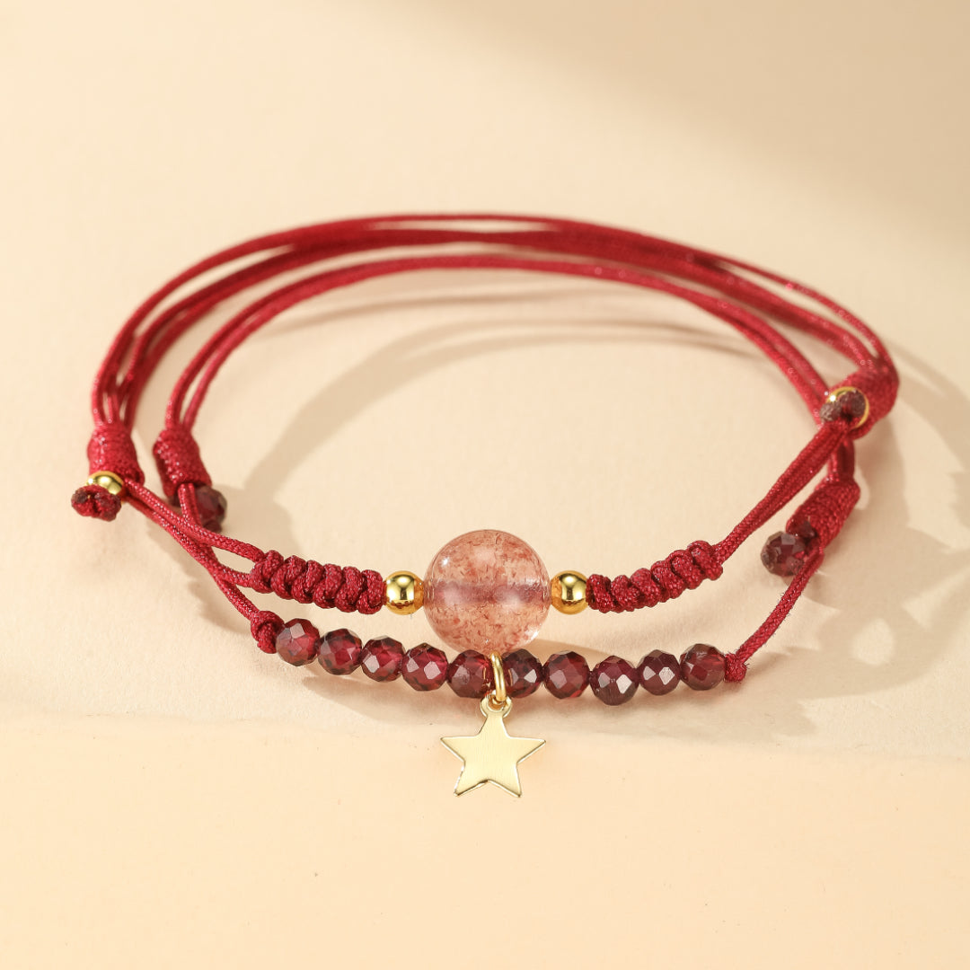 Deux bracelets fins rouges ornés de grenats et d'un quartz fraise central, avec une breloque étoile dorée.