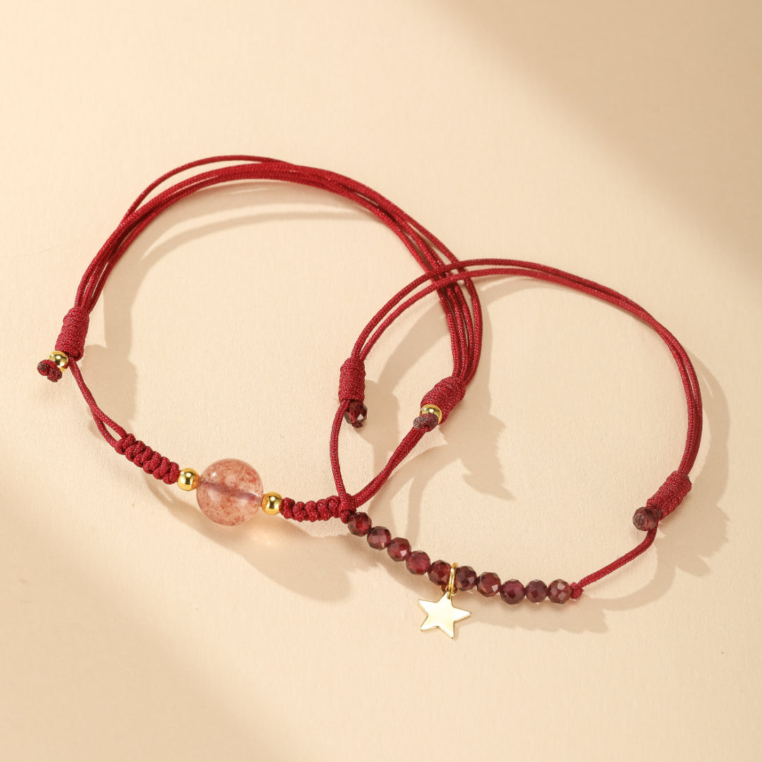 Deux bracelets en fil rouge, l'un orné d'une perle rose translucide et de perles dorées, l'autre de petites perles grenat et d'un pendentif étoile doré. "Harmonie du Destin"