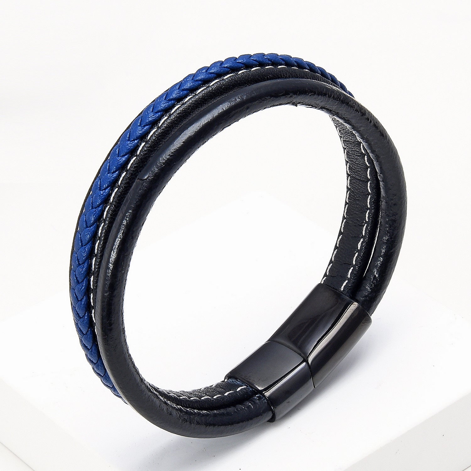 Bracelet pour homme en cuir noir avec une bande tressée bleue et coutures blanches, fermoir magnétique noir.