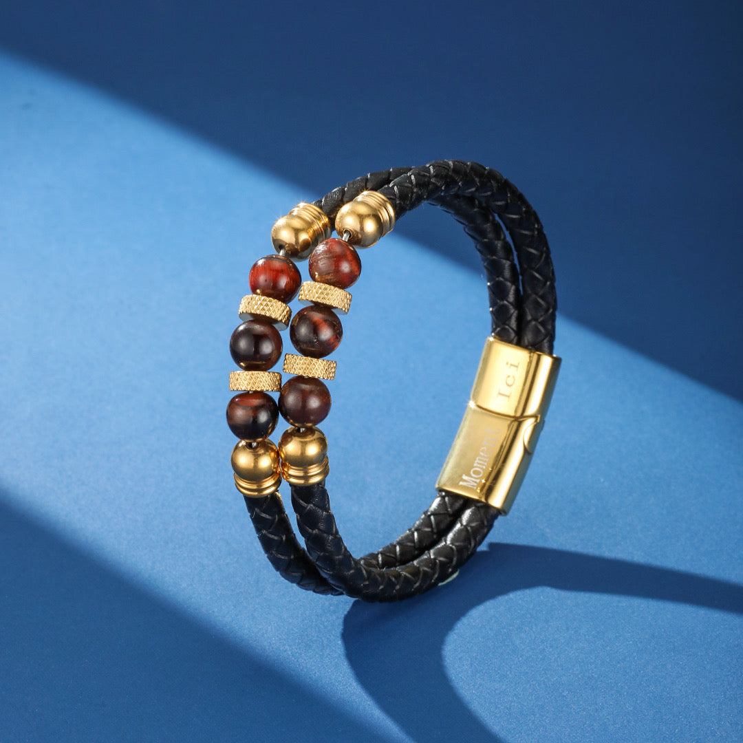 Bracelet homme double rang en cuir noir tressé avec perles œil de tigre et fermoir magnétique doré gravé 'Lei Momo'.