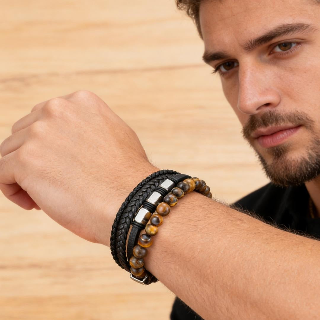 Bracelet homme en cuir tressé noir et perles œil de tigre, avec détails argentés, porté au poignet.