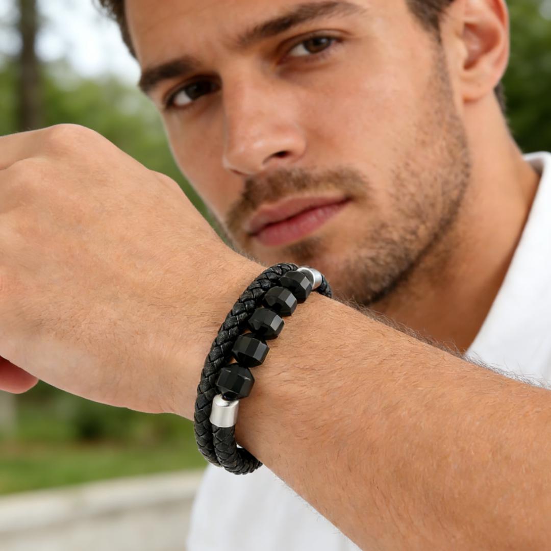 Bracelet pour homme en cuir tressé noir, orné de perles facettées noires en onyx et de détails argentés, porté au poignet.