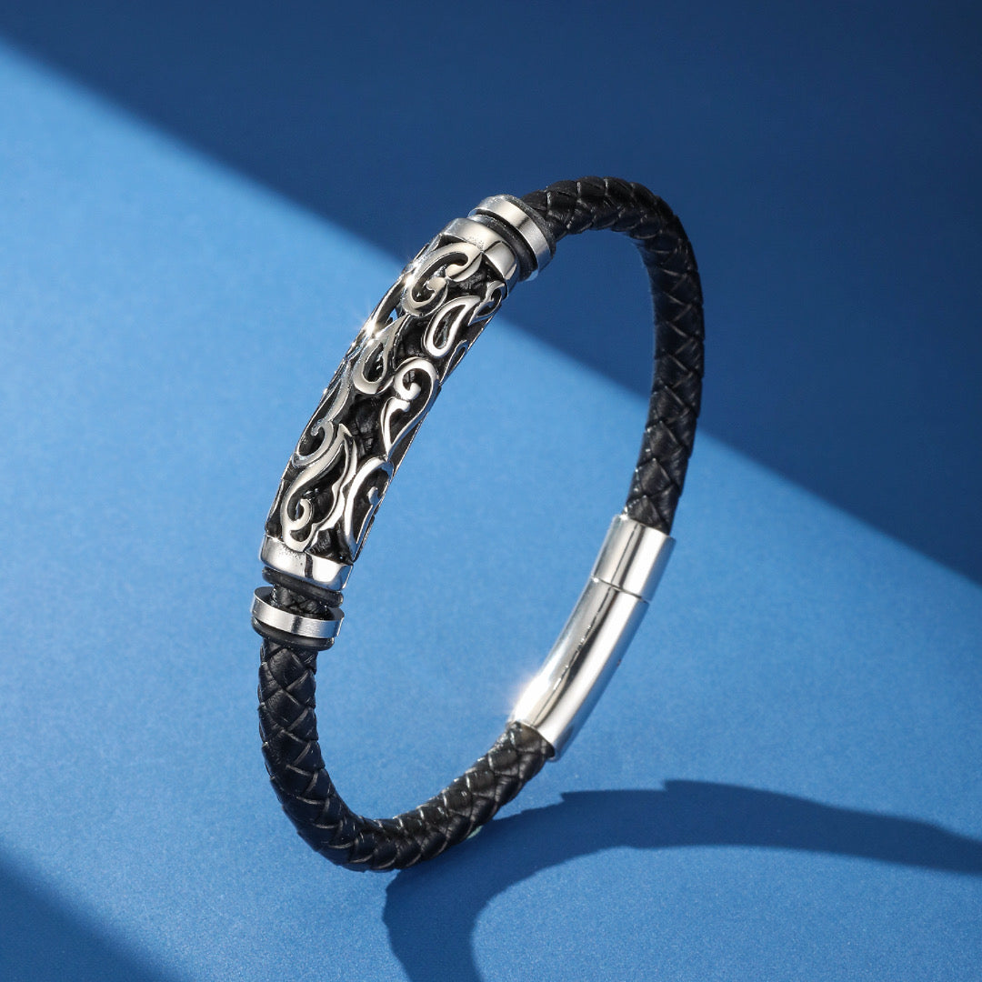 Bracelet homme tribal noir en cuir tressé avec fermoir magnétique argenté et un tube en argent orné de motifs ajourés.