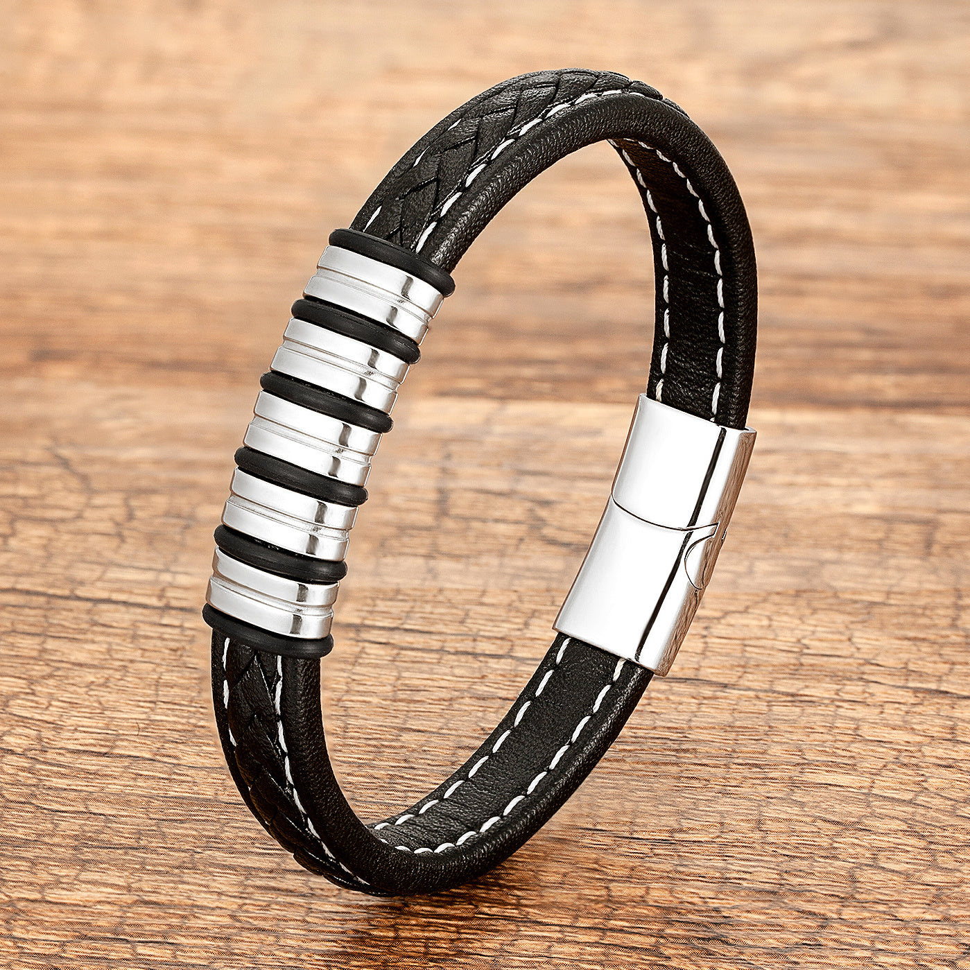 Bracelet pour homme en cuir tressé noir avec des anneaux en acier inoxydable et un fermoir magnétique argenté.