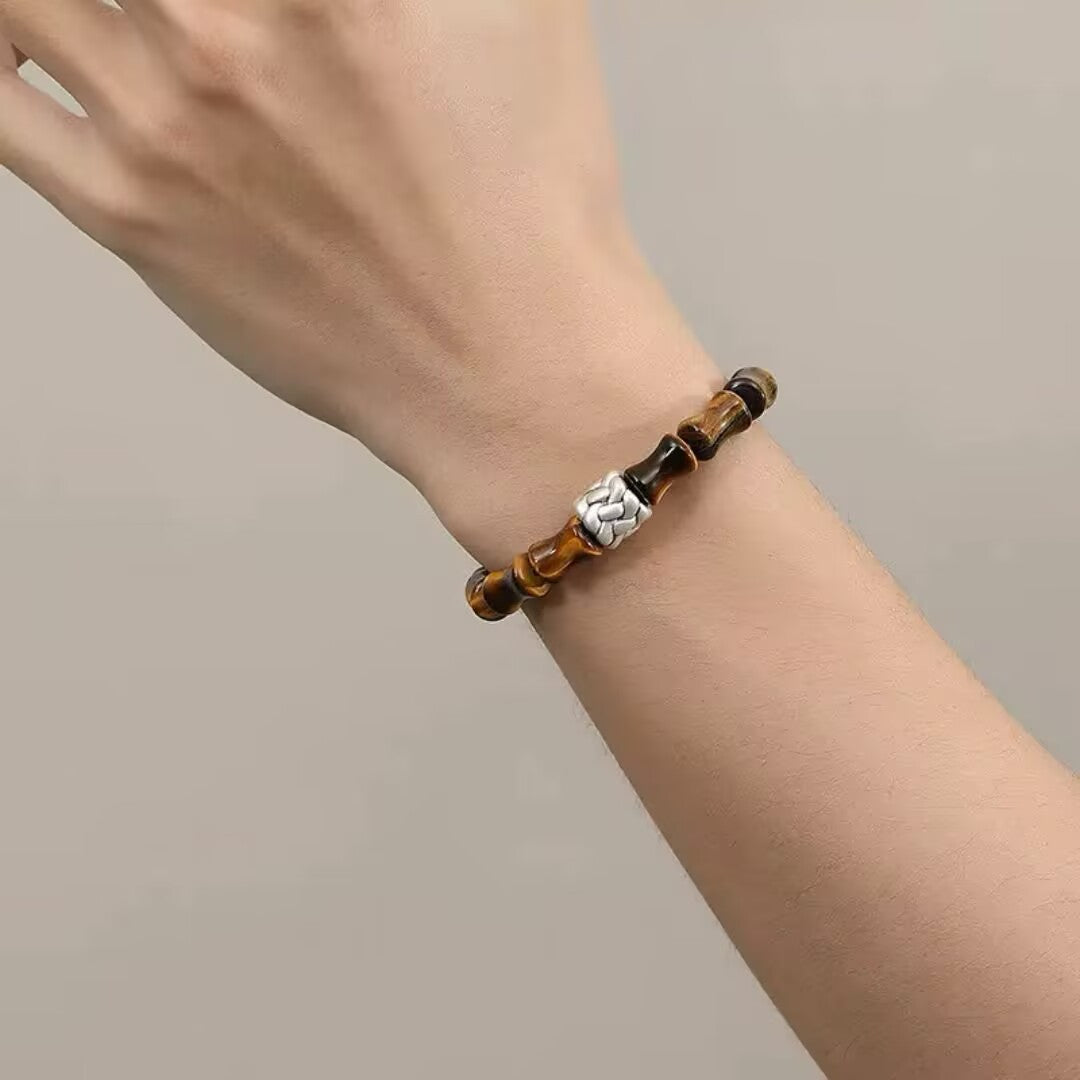 Bracelet homme en œil de tigre et argent avec un fermoir style bambou, porté au poignet.