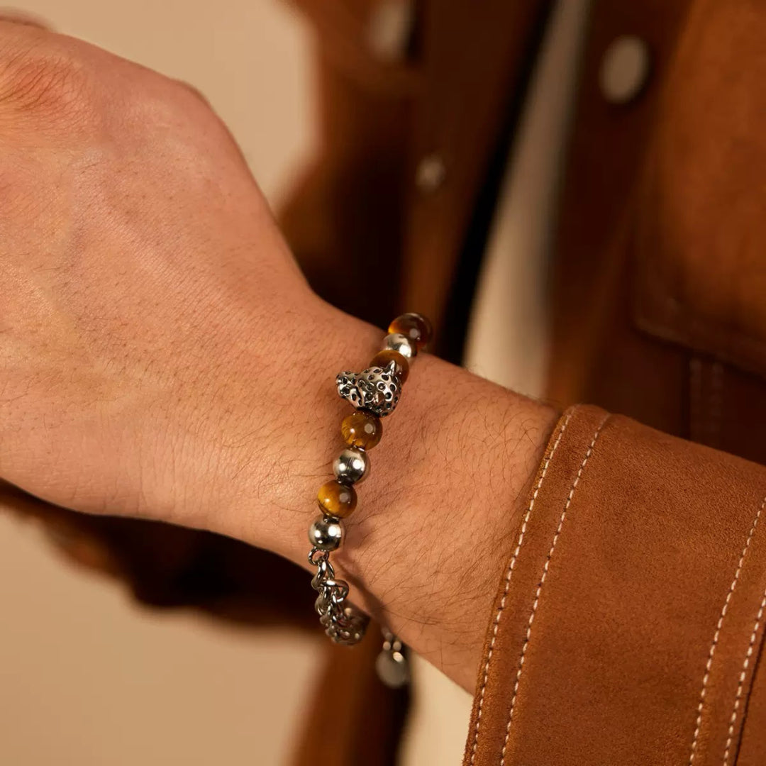 Bracelet pour homme en œil de tigre et argent avec un pendentif tête de léopard stylisé.