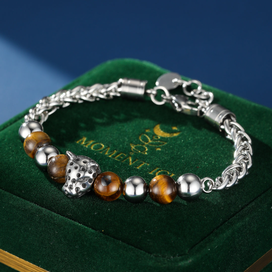Bracelet pour homme avec une tête de léopard en argent, des perles œil de tigre marron et des perles métalliques argentées, monté sur une chaîne argentée.