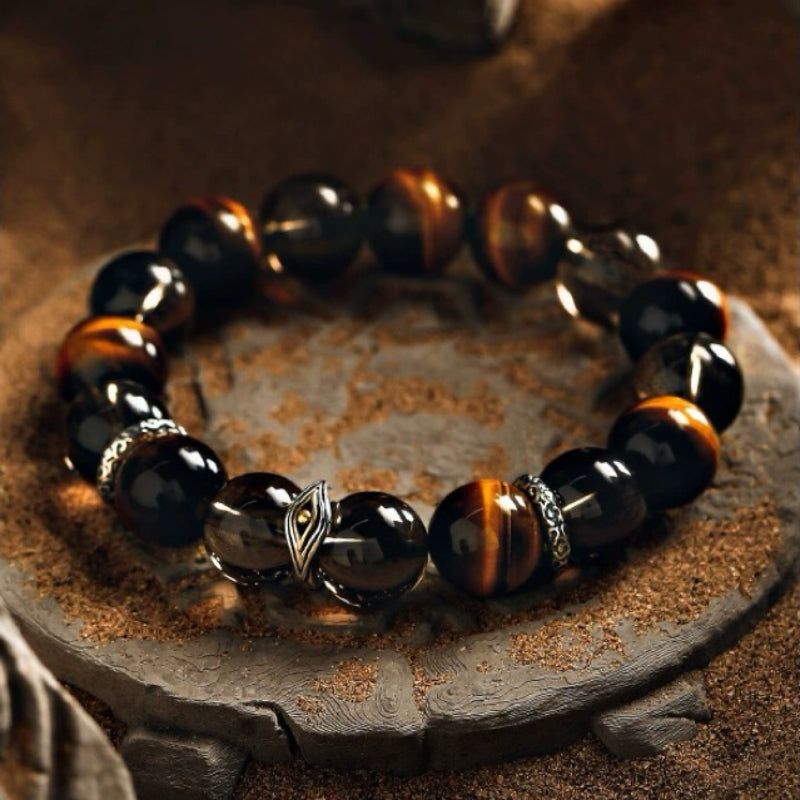 Bracelet homme en œil de tigre et œil du diable, avec des perles noires et dorées, et un fermoir en argent détaillé.