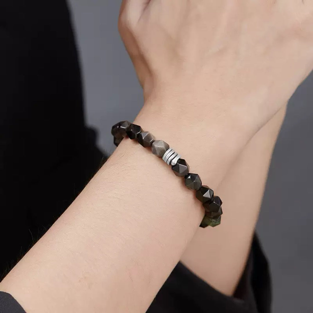 Bracelet pour homme "Esprit du Serpent" composé de perles facettées d'obsidienne, de quartz fumé et de jaspe Kambaba, avec un détail de spirale argentée.