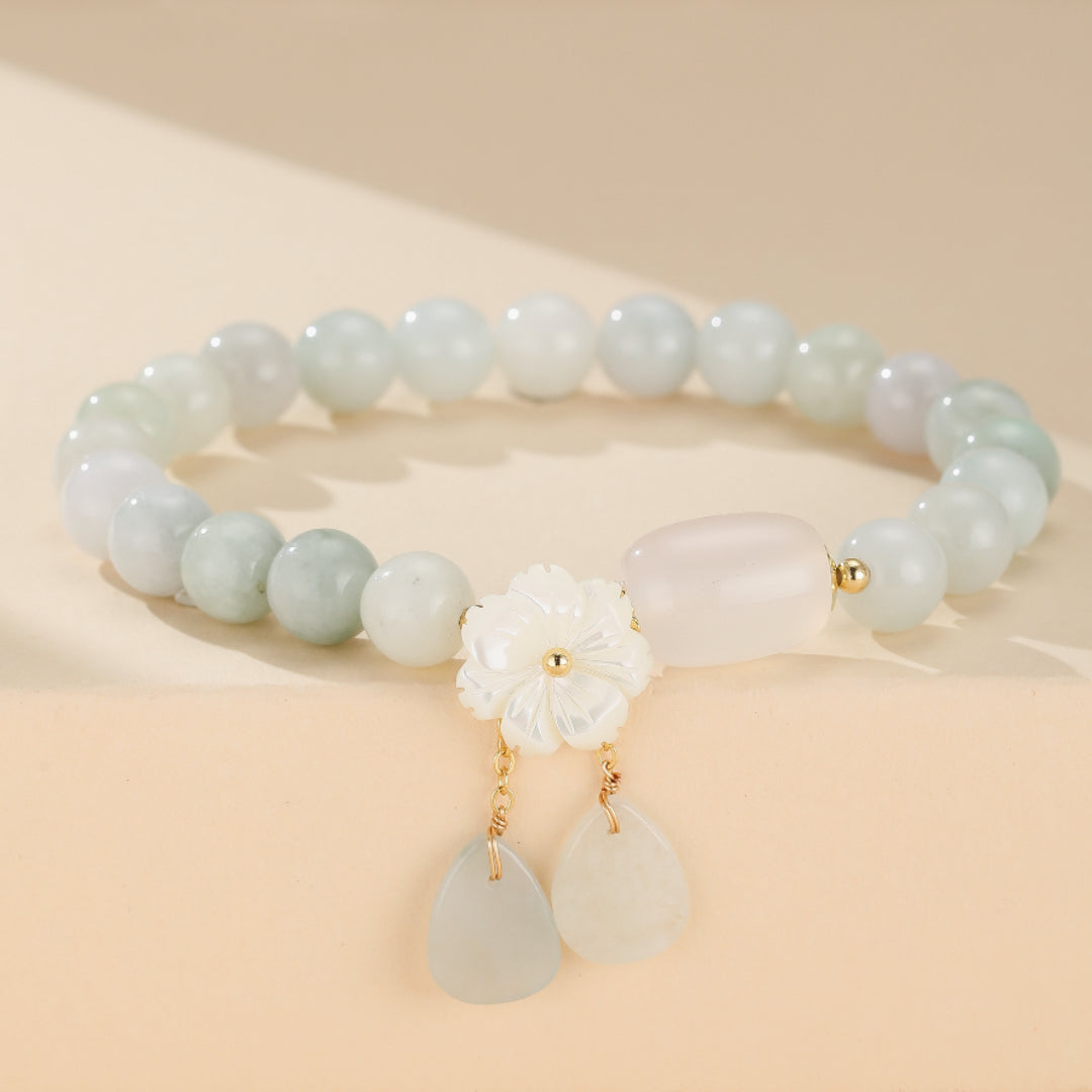 Bracelet porte-bonheur en jade blanc pur et agate équilibrante, avec perles de 8mm, accents plaqués or et fleur ciselée. Talisman de sagesse, sérénité et chance pour femme.