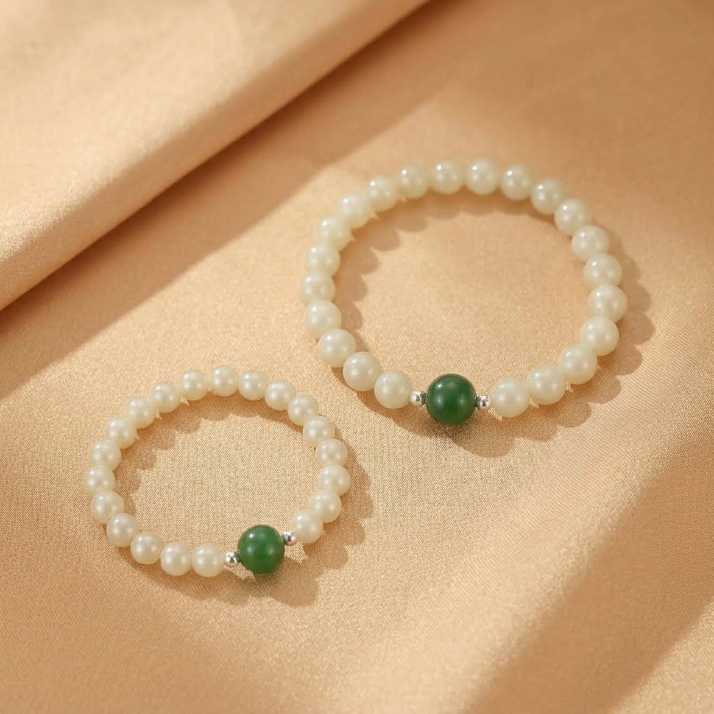 Deux bracelets "Douce Connexion" en perles blanches et jade néphrite verte, ornés d'une petite perle d'argent.