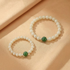 Deux bracelets "Douce Connexion" en perles blanches et jade néphrite verte, ornés d'une petite perle d'argent.