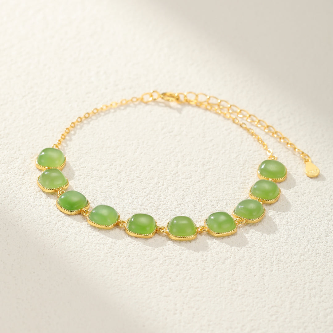 Bracelet "Perle de Lumière" en jade avec des pierres vertes et une chaîne en argent plaqué or.