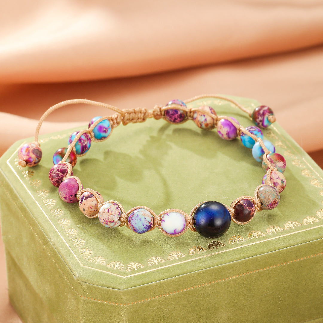 Bracelet ajustement macramé avec des perles de jaspe multicolores et une perle centrale bleue foncée.