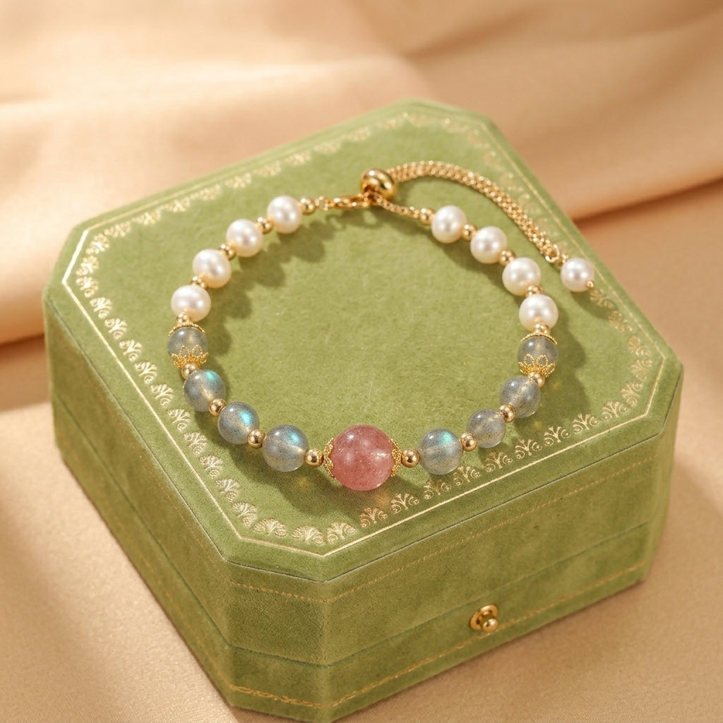 Bracelet ajustable en pierres naturelles : une grosse perle centrale rose en quartz fraise, entourée de perles bleues irisées de labradorite et de perles nacrées blanches, avec des finitions dorées.
