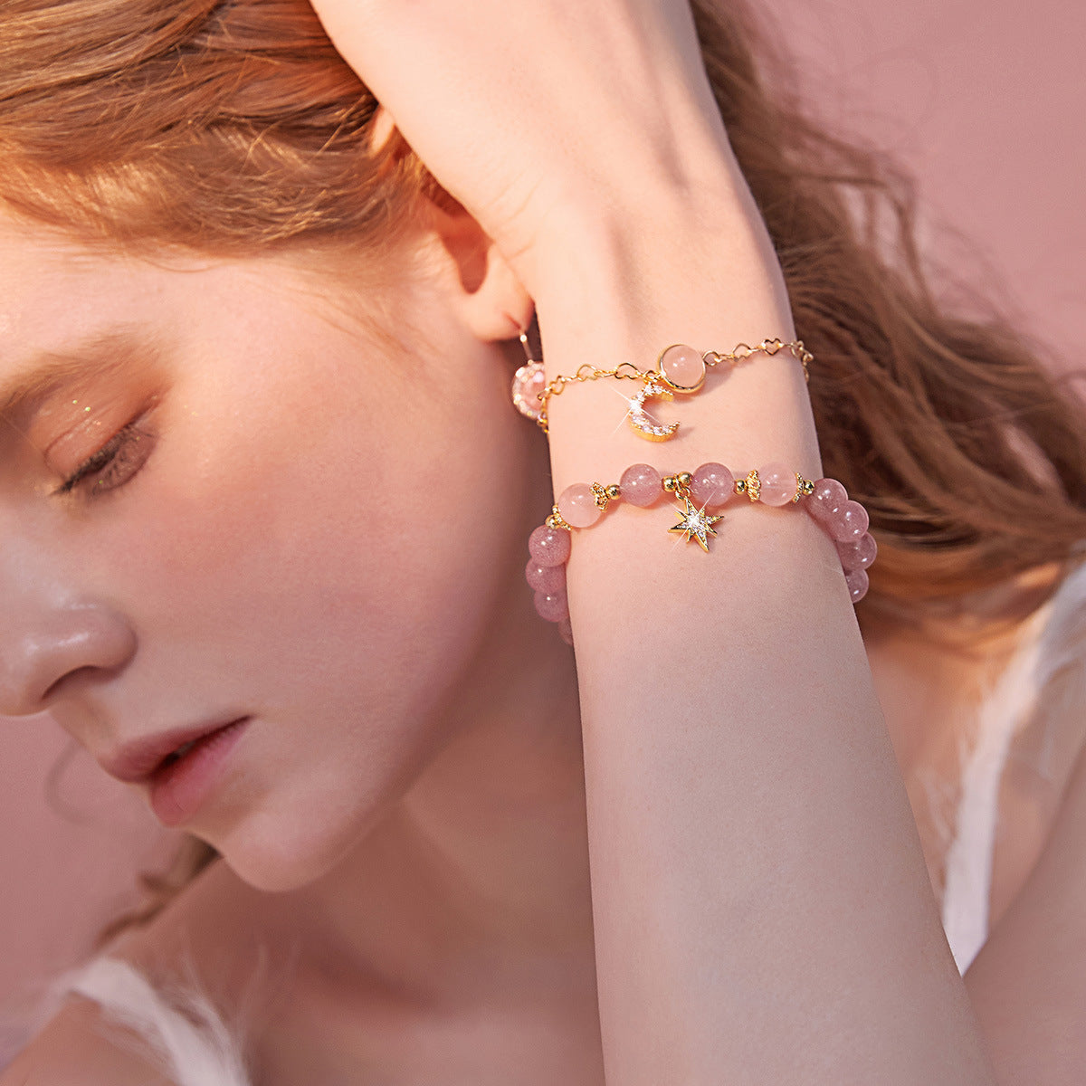 Deux bracelets délicats en quartz fraise rose, ornés de breloques lune et étoile scintillante, portés par une femme.