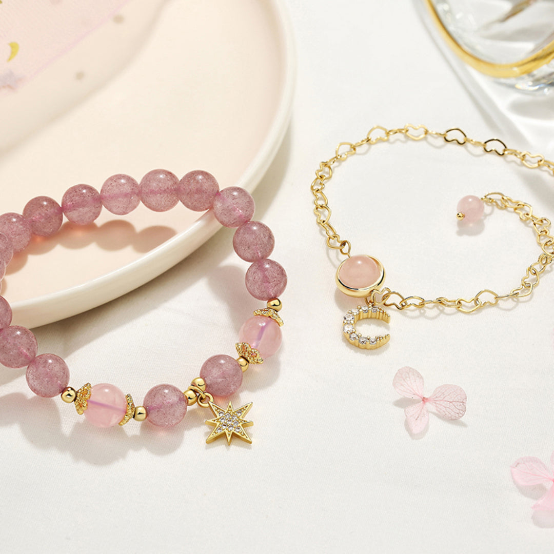 Deux bracelets fins en pierres roses, l'un orné d'une étoile et l'autre d'un croissant de lune et de cristaux.