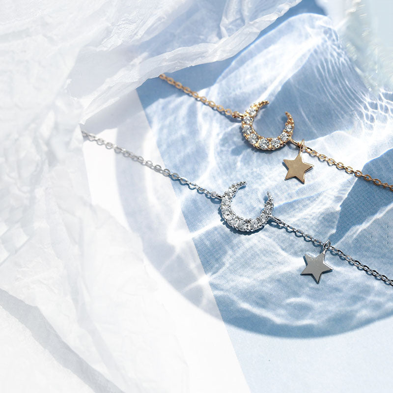 Deux bracelets, l'un en argent et l'autre doré, ornés d'un croissant de lune serti de diamants et d'une étoile suspendue.