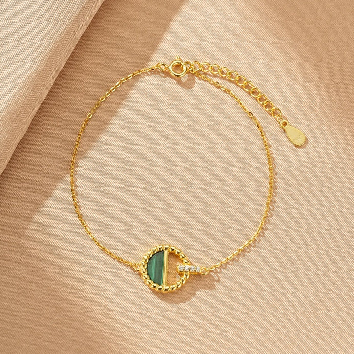 Bracelet fin en argent plaqué or avec un pendentif rond orné d'une malachite verte et d'une petite touche de diamants.