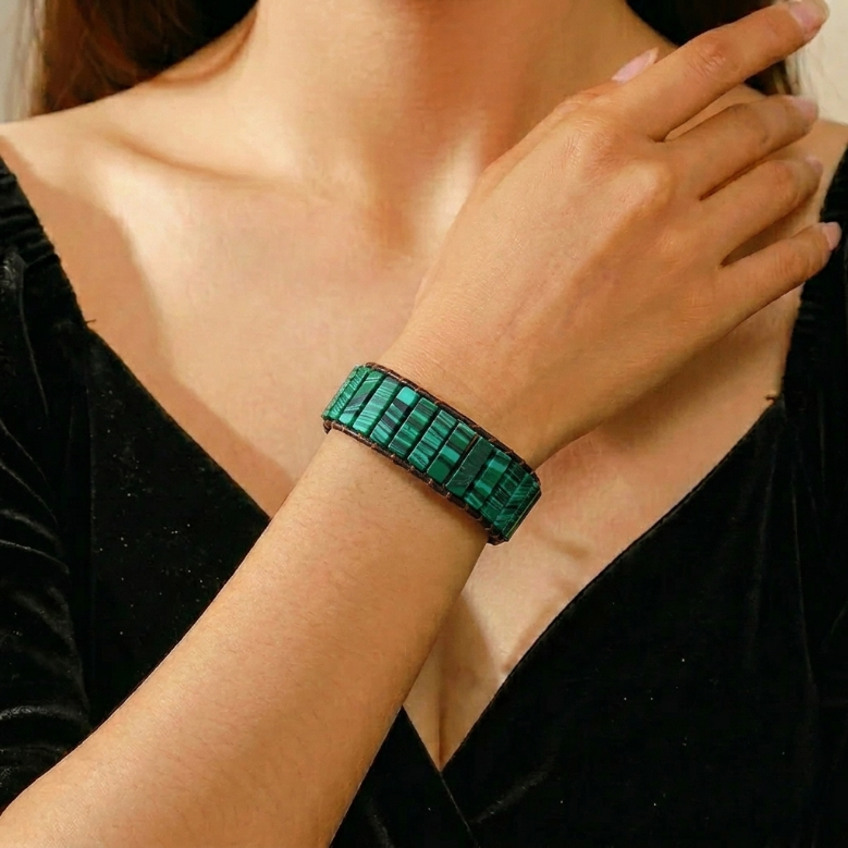 Bracelet en Malachite Vert Éternel, composé de pierres rectangulaires vertes aux motifs naturels, enroulé autour du poignet d'une femme.