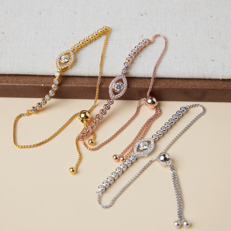 Trois bracelets réglables en argent, or et or rose ornés de l'œil maléfique serti de zirconiums.