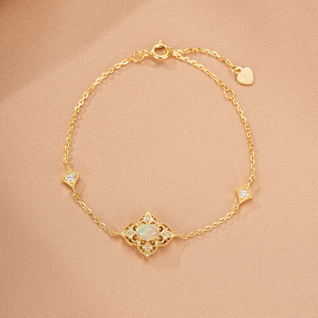 Bracelet délicat en argent plaqué or 10K orné d'une opale centrale et de petits diamants incrustés dans des motifs géométriques.