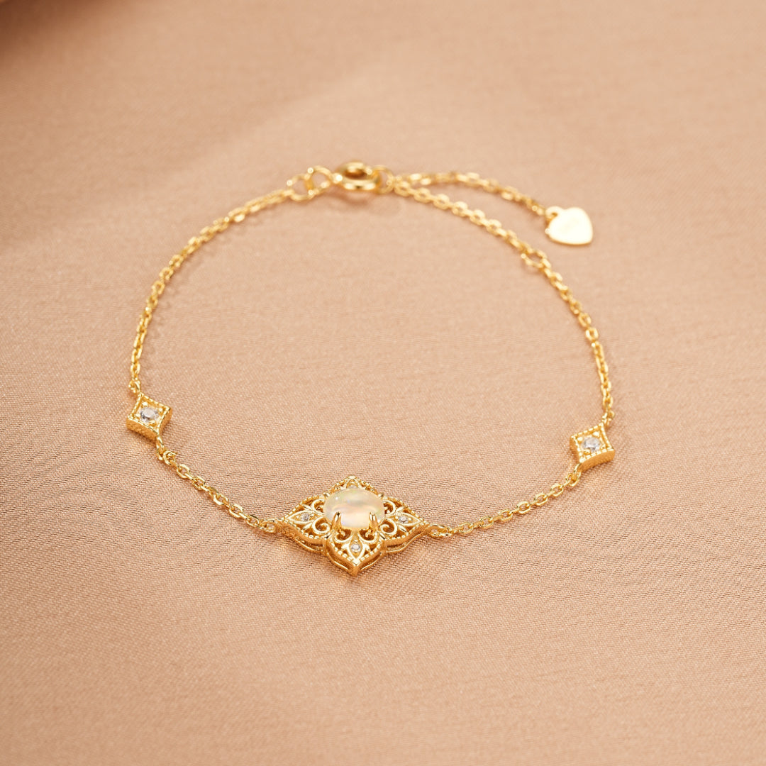 Bracelet bohème en plaqué or 10K avec une opale centrale entourée de petits diamants et de motifs carrés sur la chaîne.