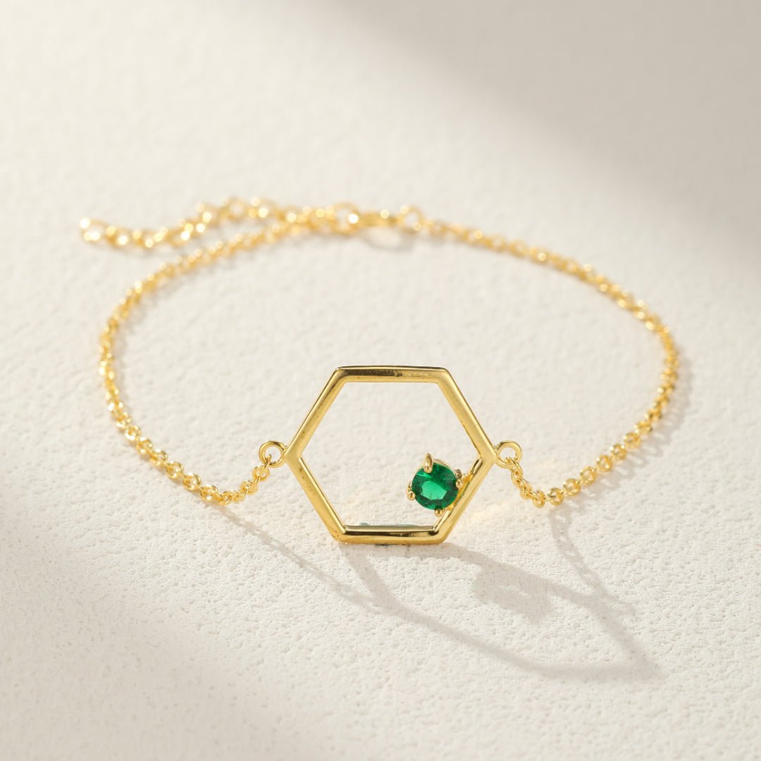 Bracelet en argent plaqué or avec un pendentif hexagone délicat et une petite pierre verte de péridot sertie à l'intérieur.