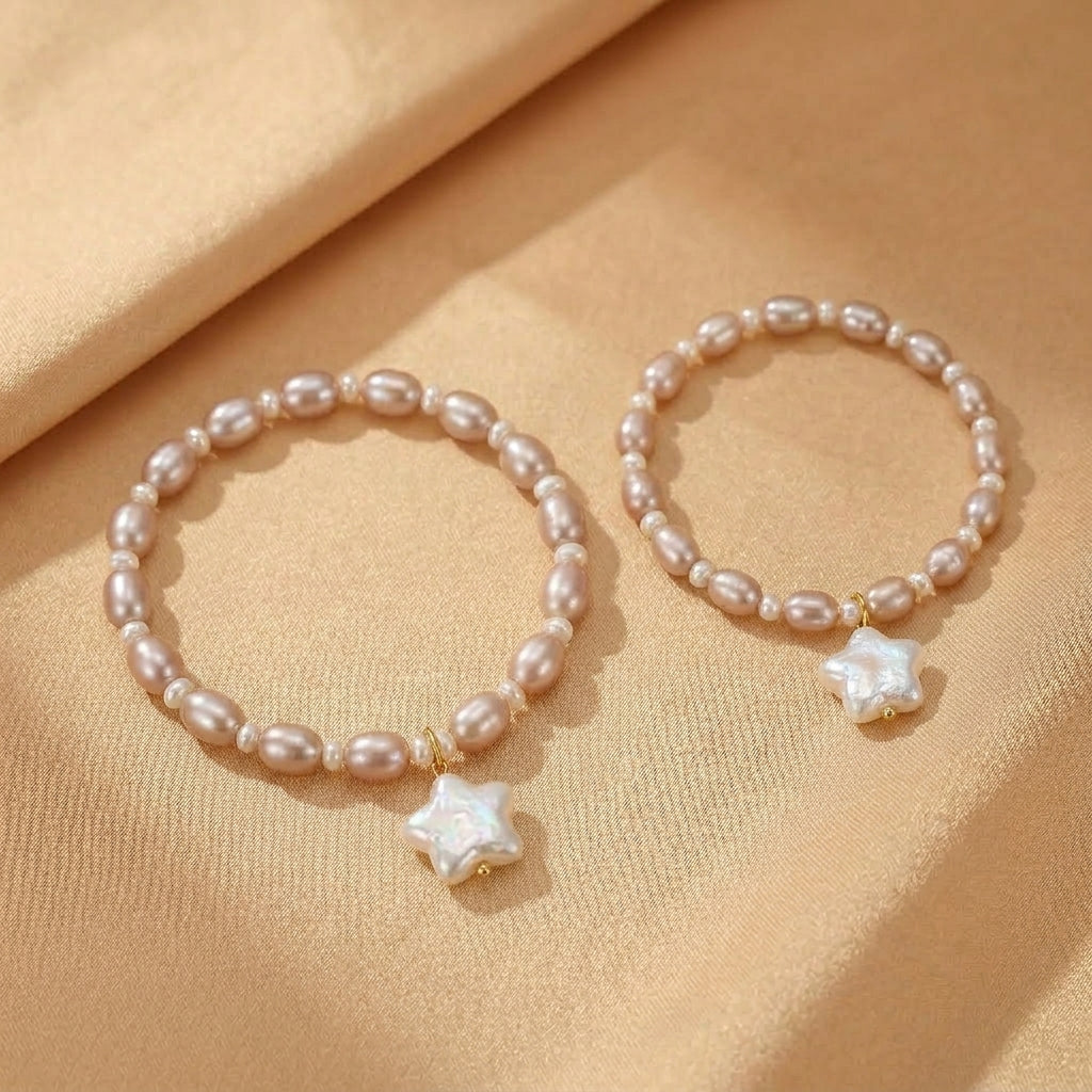 Deux bracelets en perles roses pâles avec un pendentif étoile en nacre sur un fond satiné beige.