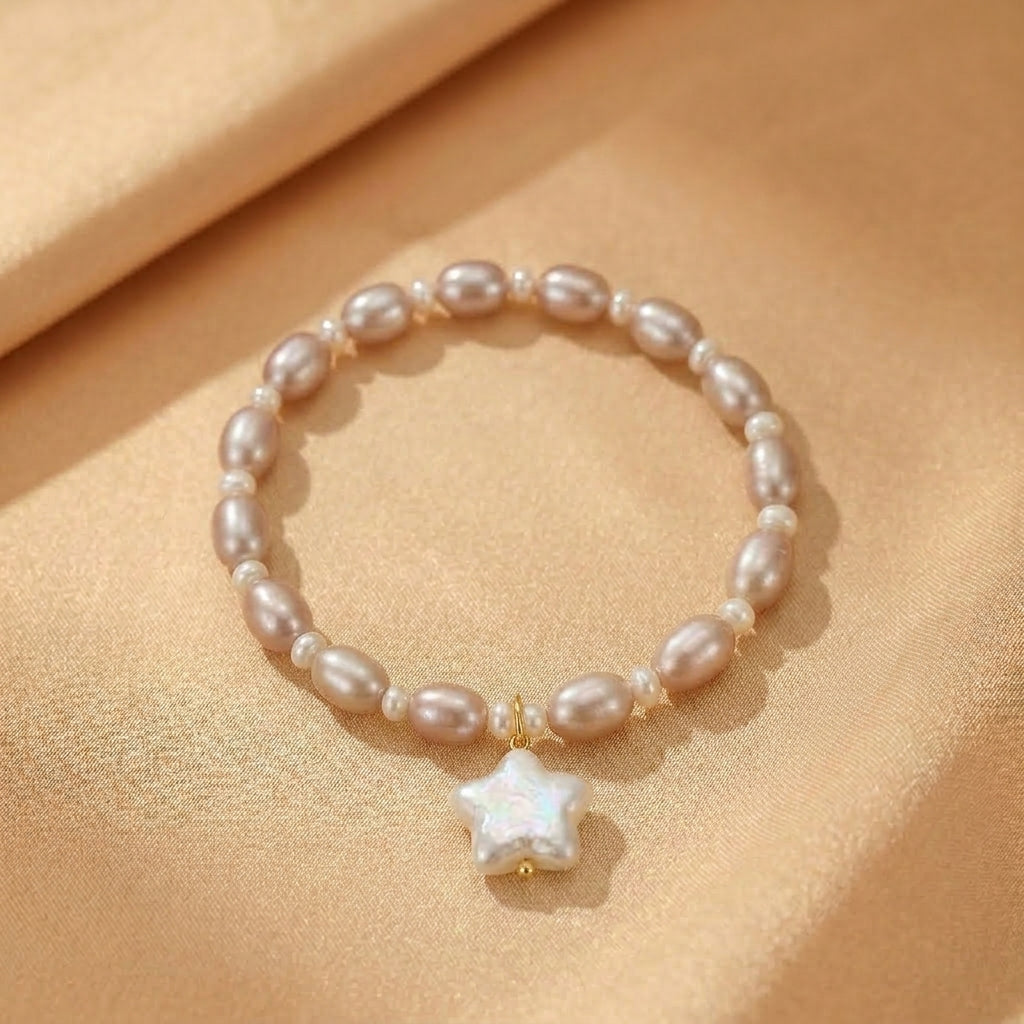 Bracelet "Souffle Infini" en perles roses pâles et pendentif étoile en nacre irisée, monté sur cordon élastique doré.