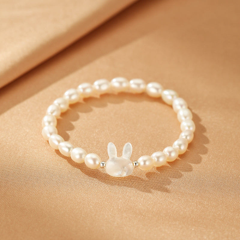 Bracelet en argent avec perles blanches et une adorable breloque en forme de tête de lapin en nacre.