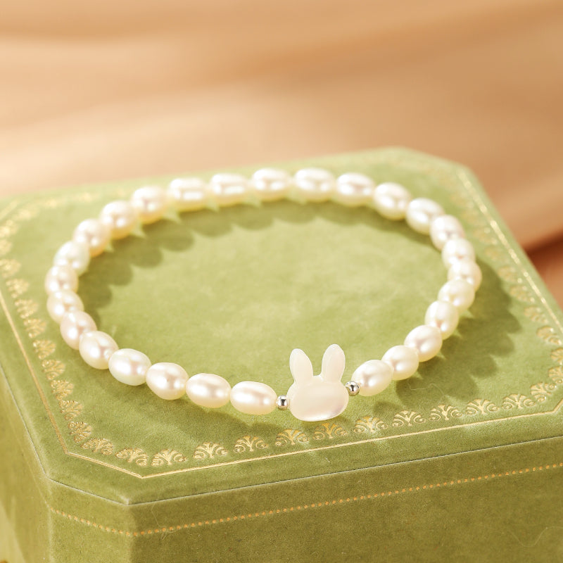 Bracelet en perles d'eau douce avec un charmant pendentif lapin en nacre, monté sur une chaîne en argent.