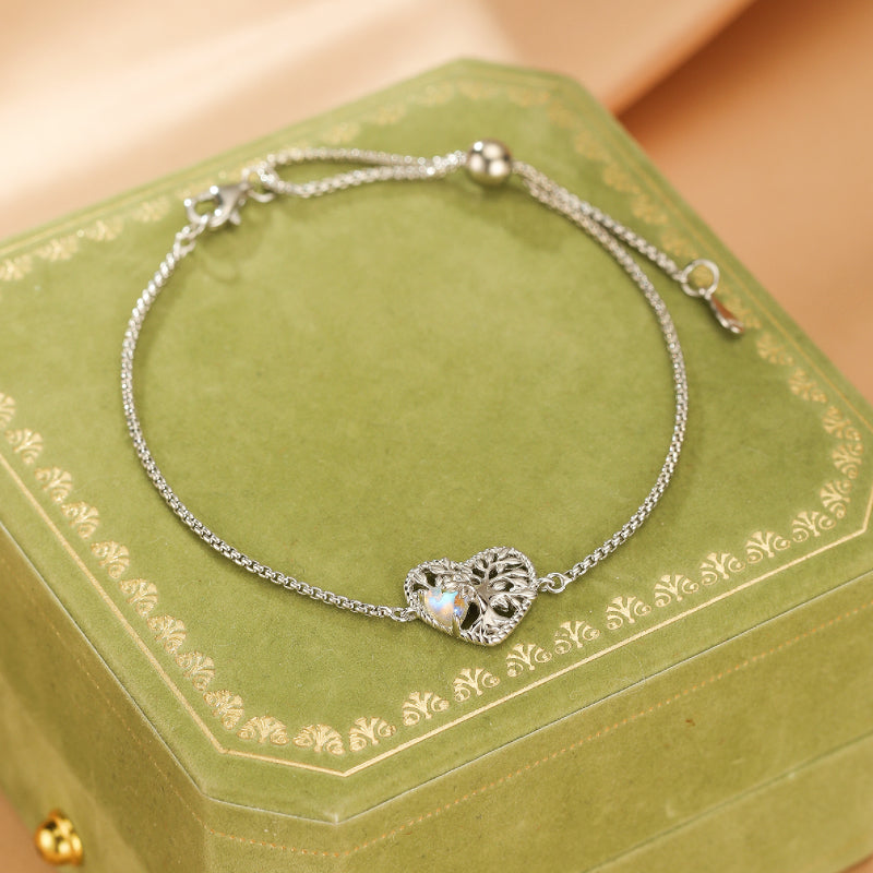 Bracelet en argent avec pendentif en forme de cœur ajouré représentant l'Arbre de Vie, orné d'une pierre de lune irisée.