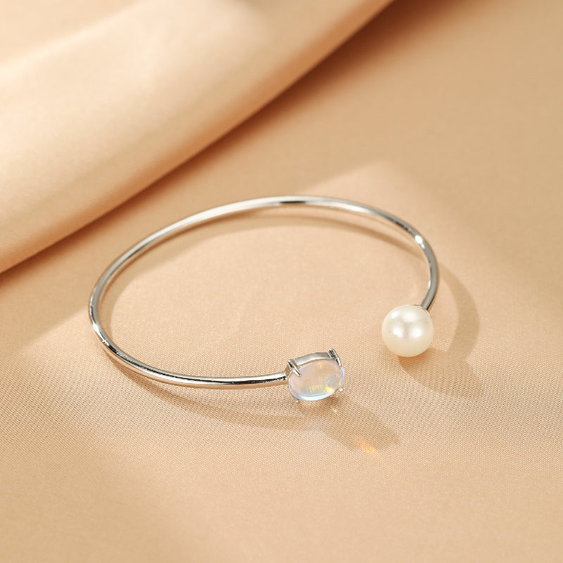 Bracelet jonc ouvert en argent 925 avec une pierre de lune ovale et une perle d'eau douce blanche, collection Essence de Lune.