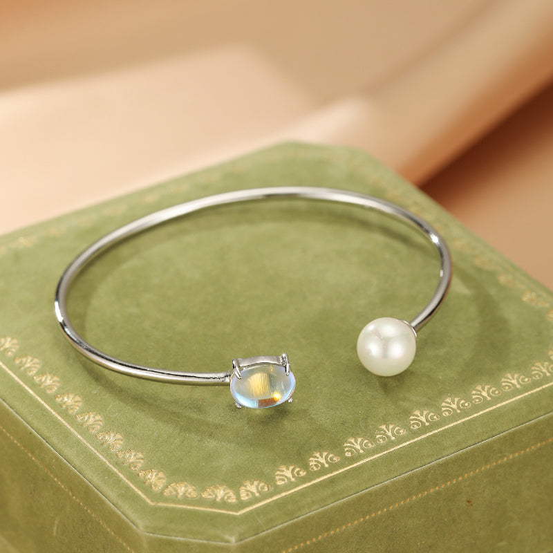 Bracelet jonc ouvert en argent 925 orné d'une pierre de lune ovale et d'une perle blanche, collection Essence de Lune.
